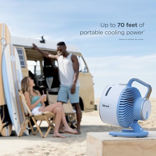 Portable fan on a beach with people near a van.